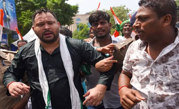 ejashwi Yadav climbing a police barricade during the Opposition march towards Lok Bhavan in Patna